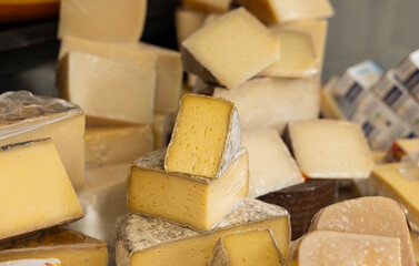 Various types of cheese on sale at a market stall. Haagse Market in The Hague, Netherlands. Dairy products, ready to eat.