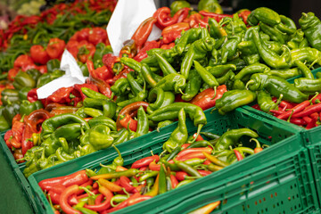 Red and green pepperoni and pepper pods on a market stall. Healthy nutrition, raw food, agriculture, harvest. Haagse Market in The Hague, Netherlands.
