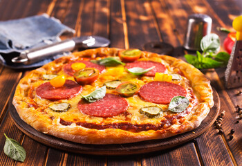 Tasty pepperoni pizza with basil on wooden table