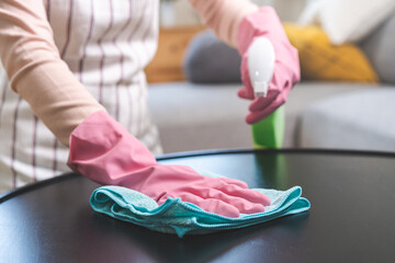 Cleanliness asian young woman working chore cleaning on table at home, hand wearing glove using rag rub remove dust with spray bottle. Household hygiene clean up, cleaner, equipment tool for cleaning