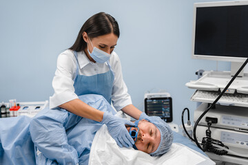 Man male patient laying at the bed while assistant holding special equipment at his mouth. Medical...