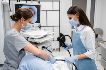 A doctor or surgeon in a light blue protective gown did a colonoscopy or gastroscopy inside...