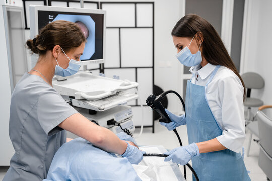 A doctor or surgeon in a light blue protective gown did a colonoscopy or gastroscopy inside operating theatre in the hospital. EGD technology for cancer screening.