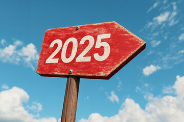  Red road sign with the number "2025" written on it, against a blue sky background. New Year concept.