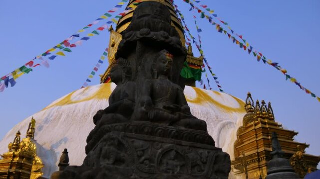 Stone sculpture or statue of Buddha in front of UNESCO world heritage site Swayambhunath Stupa a Buddhist temple with colorful Tibetan prayer flags in Kathmandu Valley.