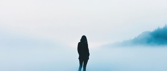 A solitary figure stands in a misty landscape, surrounded by soft hues of blue and white, evoking a sense of peace and introspection.