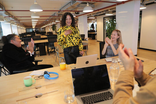 Business people clapping for colleague