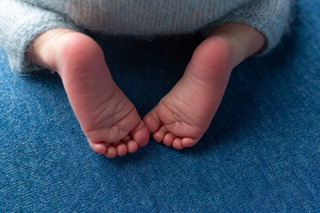 a baby's foot is on a white surface with a white sheet.