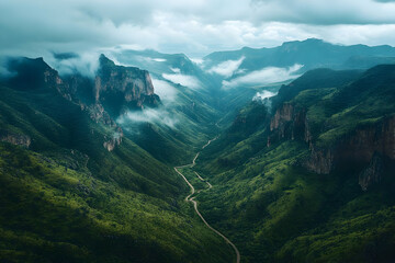 Naklejka premium Winding Road Winds Through Lush Green Valley in Mountain Range with Fog