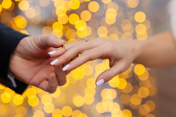 putting on a wedding ring close-up on a bokeh background. engagement 