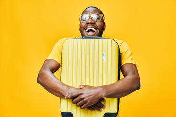 Happy traveler with a yellow suitcase, wearing glasses, joyful expression against a bright yellow background, showcasing excitement for adventure and travel Perfect for travel themed content