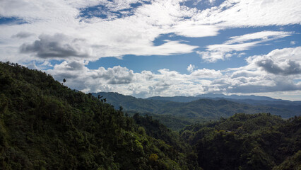 tropical mountains covered with jungle and dense vegetation against the sky, view from above