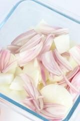 raw, chopped onion and shallots in a transparent bowl, isolated on a white background 