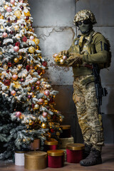 a soldier decorates a Christmas tree. a man in a military uniform decorates a Christmas tree
