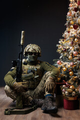 a soldier sits near a Christmas tree
