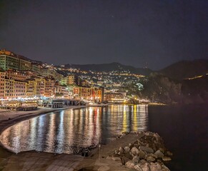 A beautiful nighttime shot of Camogli, Italy, showcasing the illuminated seaside town along the tranquil Mediterranean coastline