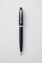 Fototapeta premium Sleek Black Ballpoint Pen with Chrome Feather Design on White Background - Elegant Office Stationery Concept with Reflective Finish for Business Cards, Catalogs, and Promotional Materials