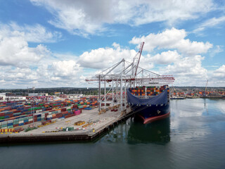 Aerial view of Industrial shipping port. View from drone. Loading containers on the ship, cranes load containers.