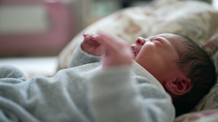 Newborn baby lying on a bed, stretching and yawning, capturing a serene and tender moment of early infancy in a calm and cozy home environment