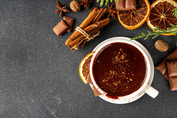 Traditional christmas hot chocolate drink cup with dried orange, cinnamon, anise, spices and...