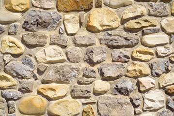 Pared de rocas en fachada exterior de casa rural en día soleado