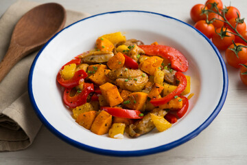 Stir-fried chicken with sweet potato, pineapple and red pepper. Top view table with  decorations.