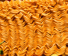 Overhead view of spicy ramen noodles, top view of orange spicy noodles