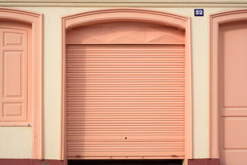 Puertas pintadas de rosa en fachada de edificio elegante en ciudad europea