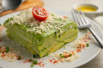 Baked potatoes with spinach bechamel and cheese.