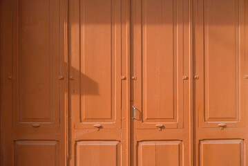 Puerta de madera con cuadrados ornamentales pintada de marrón