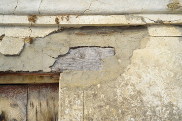 Desconchón de muro en viga de puerta rústica abandonada