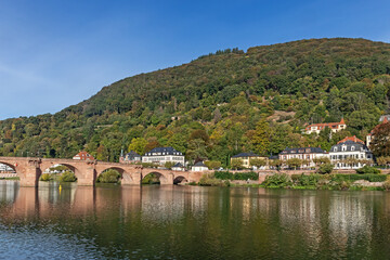 Naklejka premium Der Heiligenberg am Rand des Odenwalds bei Heidelberg in Baden-Württemberg, Deutschland mit Wald, Villen im Stadtteil Neuenheim und der Alten Brücke über den Neckar.
