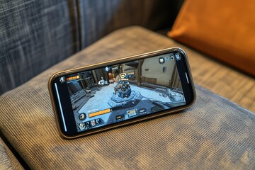 Smartphone on a coffee table with augmented reality app open showing a virtual game overlay.