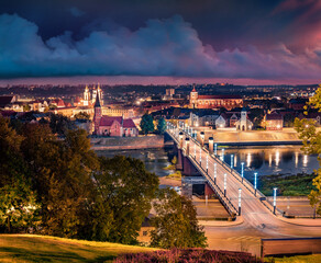 Night autumn cityscape of Kaunas town with Church of Vytautas the Great on background. Illuminated...