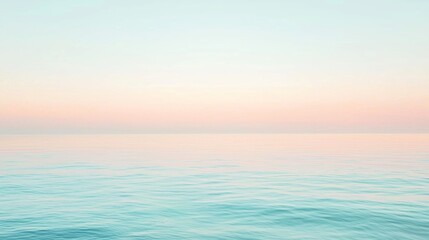 Obraz premium The calm ocean reflects soft pastel colors at sunrise, creating a tranquil and idyllic seascape perfect for travel or summer designs