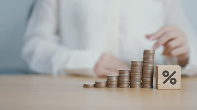 wood block of percentage with money coins stack. Interest rate, GDP, stocks market, financial, deflation and Inflation, business Growth, mortgage, debt, Loan and Economic Recession