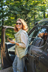 Young beautiful woman traveling by car using smartphone , vacation and adventure