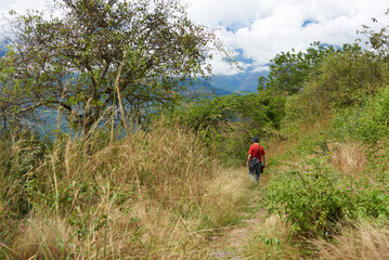 Unrecognizable man walking on a rural path, a restored stone royal way, going from Barichara to Guane, in Santander, Colombia. Concept: ecotourism, healthy and active lifestyle in nature.