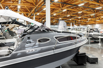 Many small big ship yachts at boat show exhibition indoors hall. Marine fishing yachting sailing...