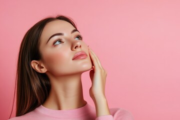 Attractive charming calm young woman applying cream on clean skin of face isolated on pink background with copy space