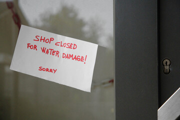 Sign posted in the shop window: Closed due to flood and water damage