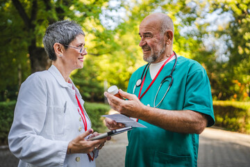 Two doctors discuss about prescription and ultrasound picture outside