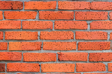 Obraz premium Close-up of a red brick wall with visible mortar lines.