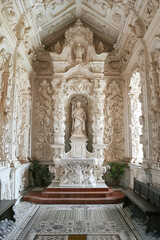 Obraz premium Ornate baroque-style chapel interior with intricate carvings and a central religious statue.