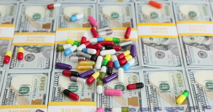 Hands holding medical pills and a stack of hundred dollar bills