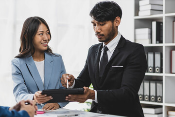 Business colleagues working and analyzing financial figures on a digital tablet. Analysis business financial report on digital tablet discussion meeting corporate showing results of their successful.