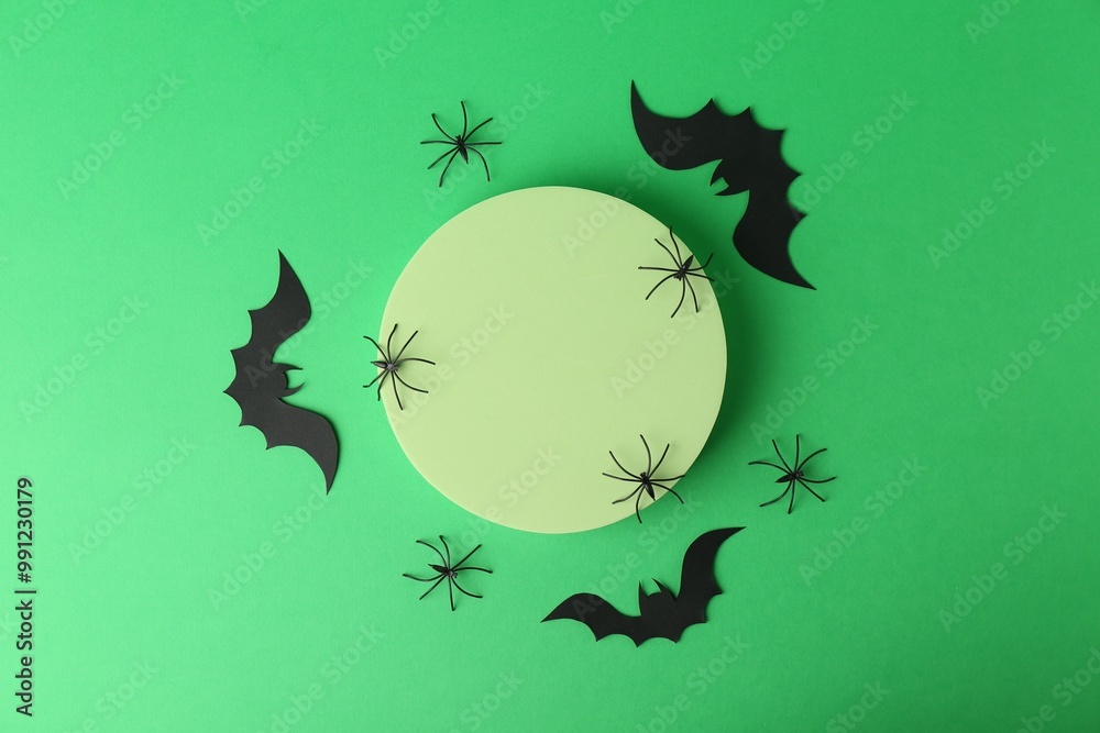 Canvas Prints Halloween celebration. Podium, decorative bats and spiders on green background, flat lay. Space for text