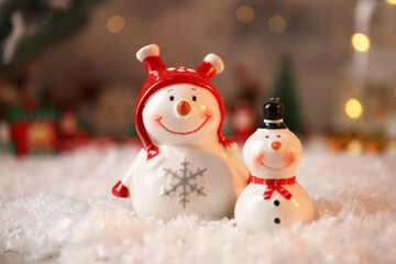 Funny snowmen figures on artificial snow, closeup