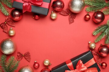 Flat lay composition with Christmas decor and gift boxes on red background, space for text