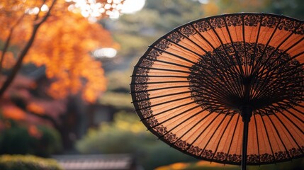 A close-up of a Japanese paper umbrella with intricate patterns, set against a blurred garden background.
